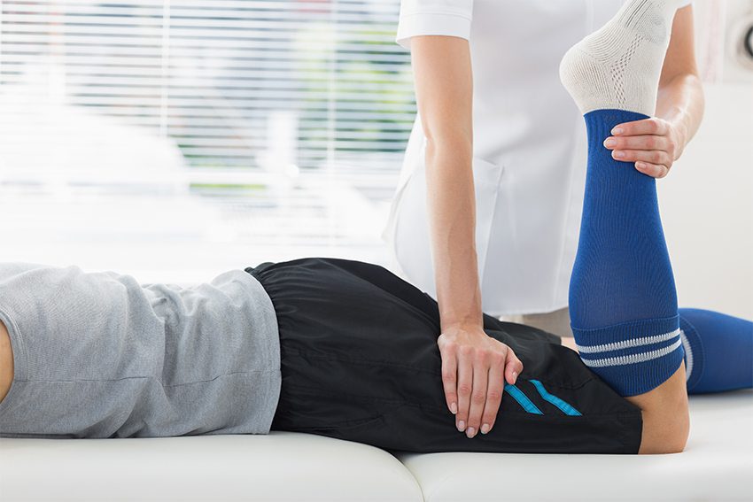 Therapist supporting patient during physiotherapy session for injury recovery.