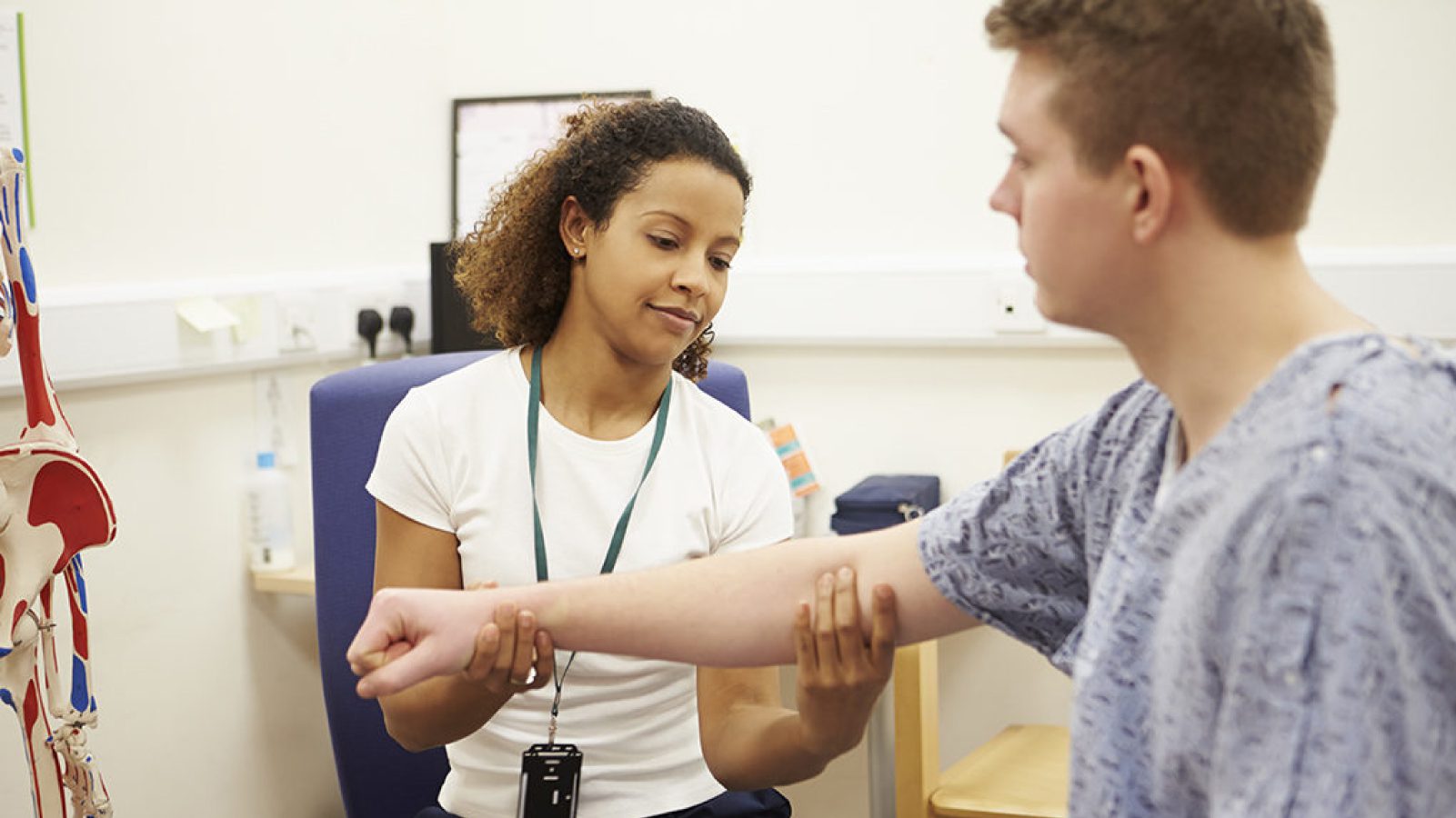 Physiotherapist assessing patient’s arm mobility during clinical evaluation, representing fair compensation for healthcare providers.
