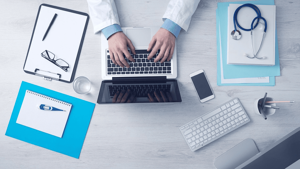 Man on computer with medical equipment near him