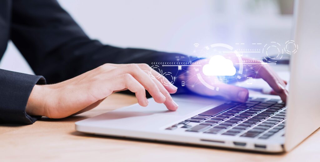 Person typing on laptop with digital cloud security icon representing data security.